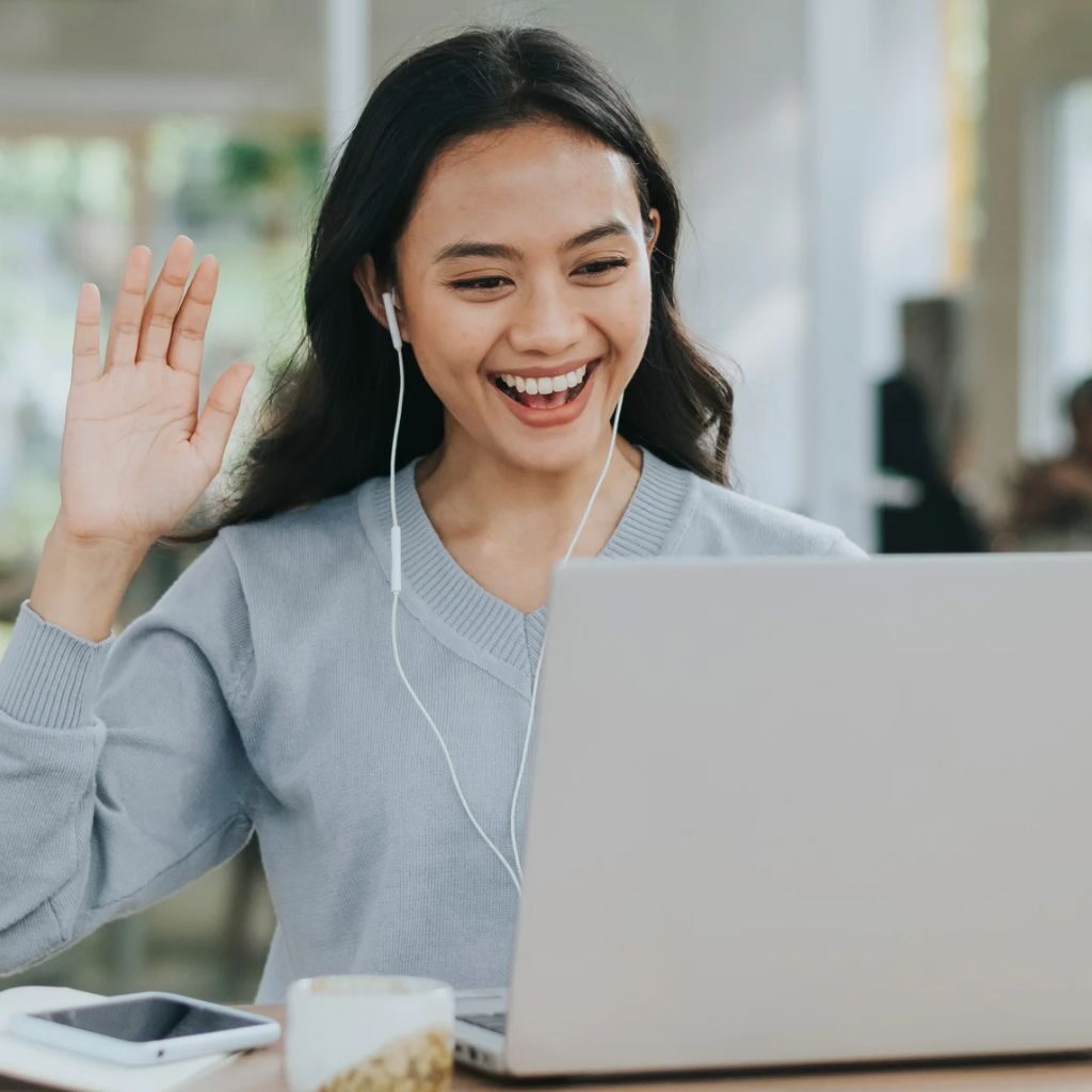 Mulher acenando para notebook participando de um recrutamento online